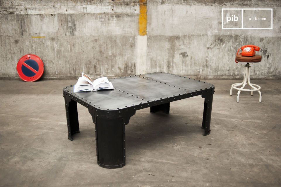 Hermosa mesa de centro de acero oscuro con remaches visibles.