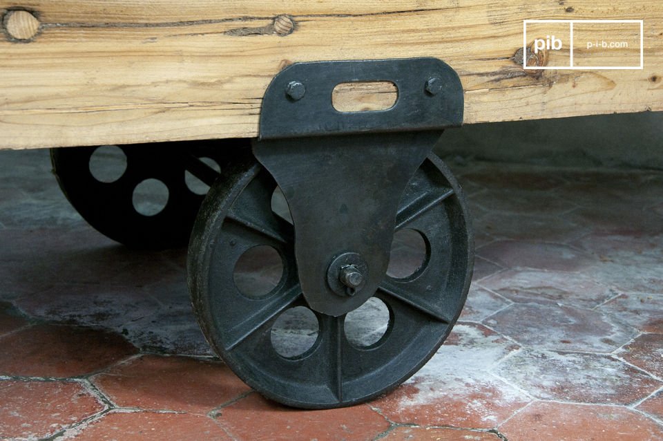 La mesa es de madera barnizada de gran espesor, montada sobre ruedas de hierro fundido.