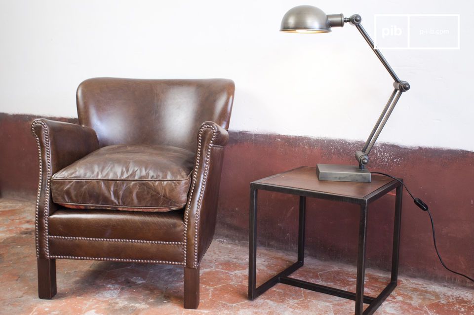 Sillón Club combinado armoniosamente con una lámpara articulada retro.