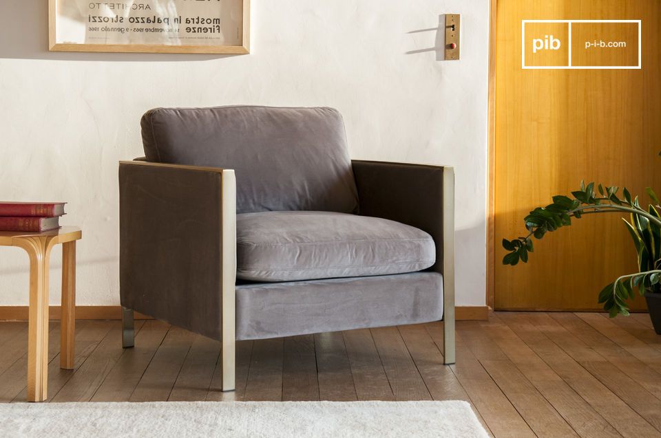 Sillón de terciopelo gris con estructura metálica dorada.