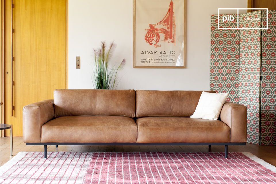 Un sofá con un diseño armonioso, elegantemente apoyado en una estructura metálica.